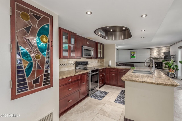 kitchen with stainless steel appliances, a sink, tasteful backsplash, light stone counters, and recessed lighting