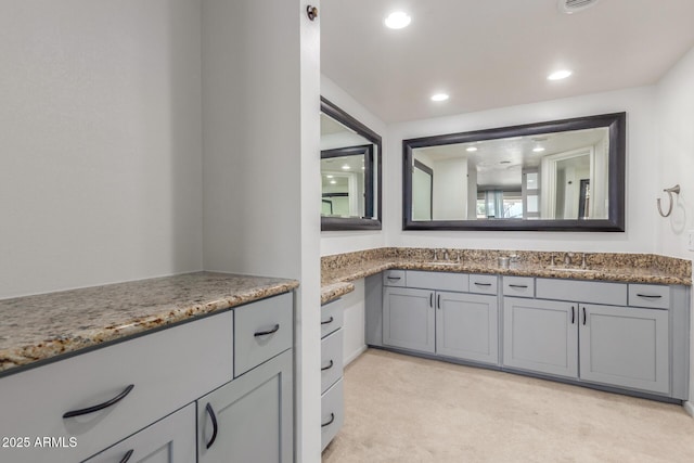 bathroom with double vanity and recessed lighting