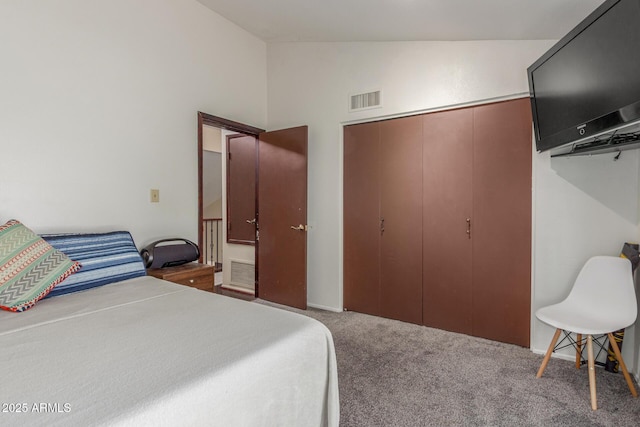 bedroom with vaulted ceiling, carpet flooring, and a closet