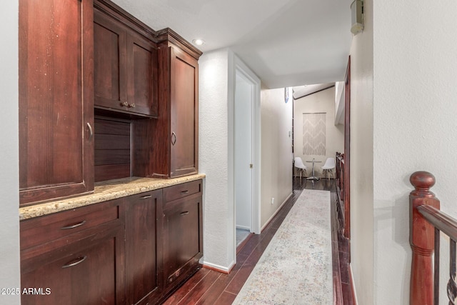 corridor featuring dark wood-style flooring, baseboards, and recessed lighting