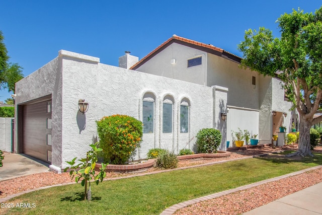 mediterranean / spanish house featuring an attached garage, stucco siding, and driveway