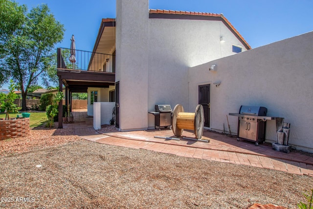 back of house with a patio area, a balcony, and stucco siding