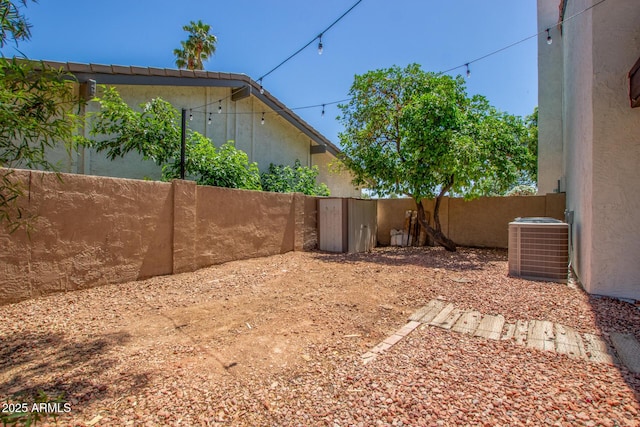 view of yard with fence and central air condition unit