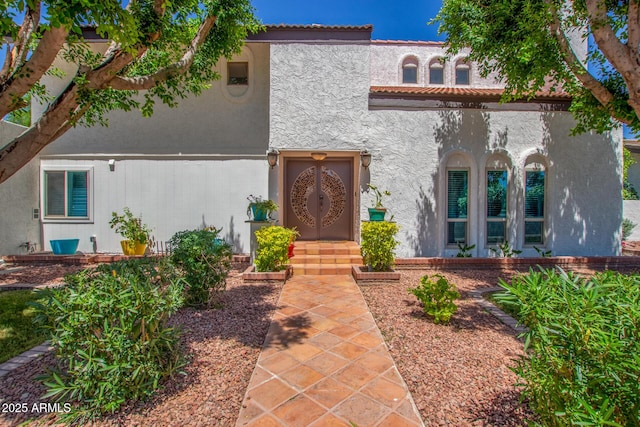 mediterranean / spanish-style house with stucco siding and a tiled roof