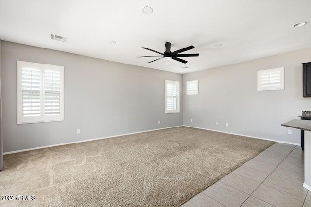 carpeted spare room with ceiling fan