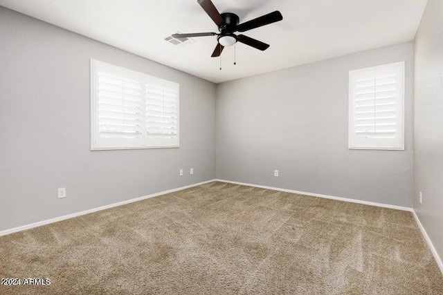 empty room with ceiling fan and carpet floors