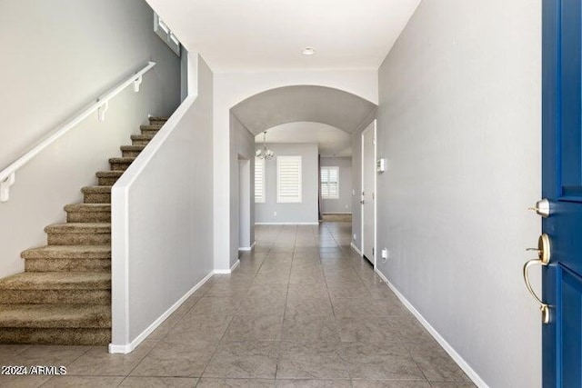 foyer entrance with an inviting chandelier and light tile patterned floors