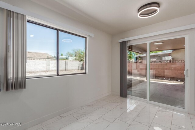 8508 W Clarendon Ave W, Phoenix, AZ 85037 - empty room with plenty of natural light, baseboards, and marble finish floor
