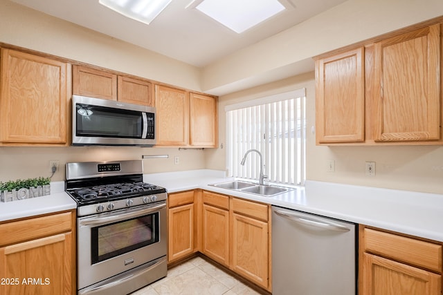 kitchen with sink, light brown cabinetry, light tile patterned floors, and stainless steel appliances