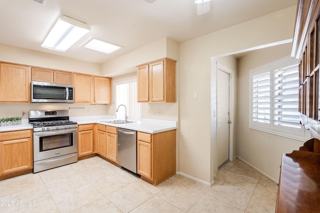 kitchen with sink, plenty of natural light, light brown cabinetry, and stainless steel appliances