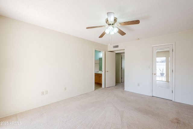 carpeted spare room featuring ceiling fan and a textured ceiling