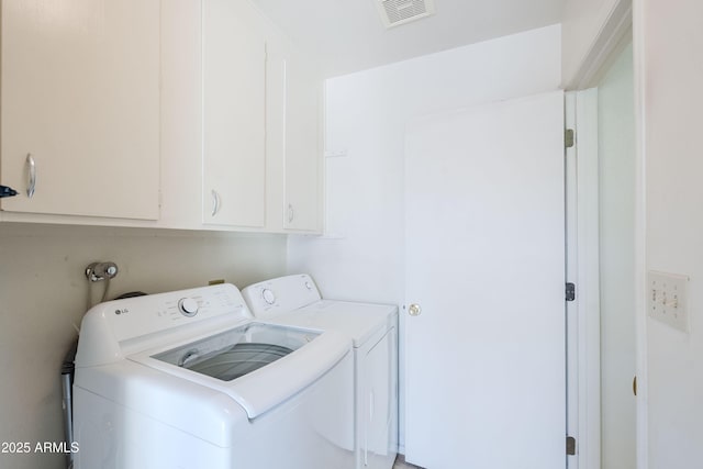 washroom with washing machine and clothes dryer and cabinets