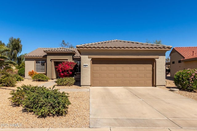view of front facade featuring a tile roof, stucco siding, concrete driveway, and a garage