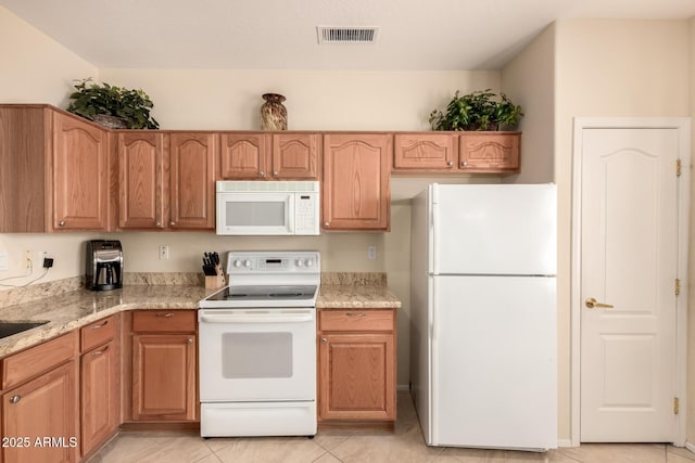 kitchen featuring white appliances, light stone counters, light tile patterned flooring, and visible vents