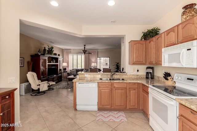 kitchen featuring white appliances, light tile patterned floors, open floor plan, and a sink