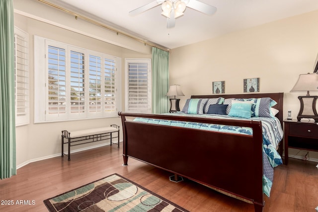 bedroom featuring wood finished floors, baseboards, and ceiling fan