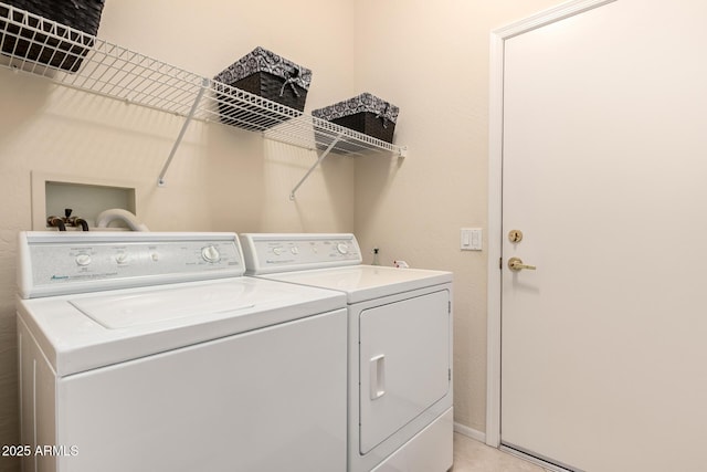 laundry area with laundry area, washing machine and dryer, and baseboards