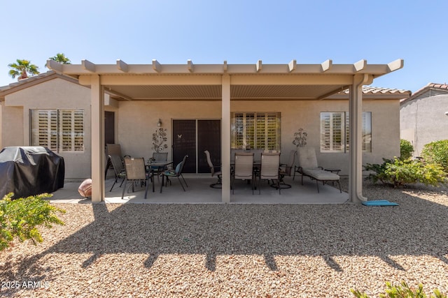 back of house with outdoor dining space, stucco siding, a tile roof, and a patio