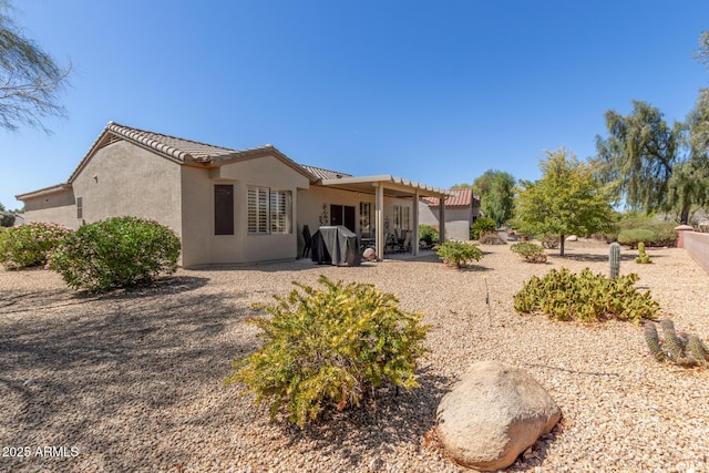 back of property featuring a patio area, stucco siding, and a tiled roof