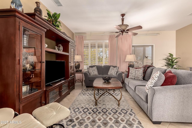 living area with visible vents, light tile patterned flooring, and a ceiling fan