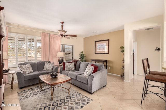 living area featuring light tile patterned floors, visible vents, baseboards, and a ceiling fan