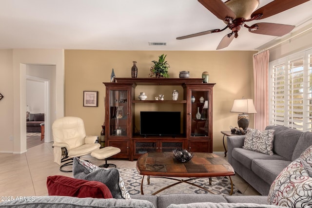 living room with tile patterned floors, visible vents, and a ceiling fan