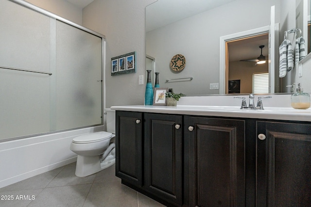 full bathroom with tile patterned flooring, bath / shower combo with glass door, vanity, and toilet