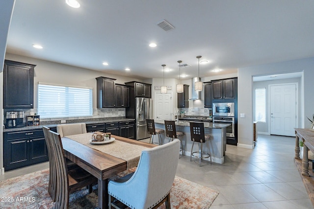 dining area featuring sink and light tile patterned floors