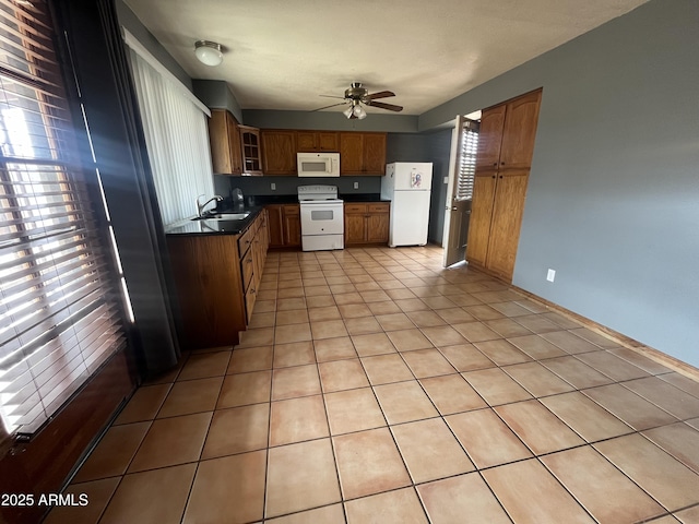 kitchen with white appliances, brown cabinetry, dark countertops, glass insert cabinets, and light tile patterned flooring