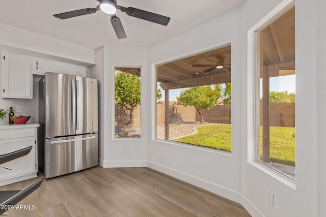 kitchen featuring ceiling fan, white cabinetry, stainless steel refrigerator, and light hardwood / wood-style floors