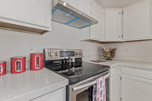 kitchen with stainless steel electric stove and white cabinetry