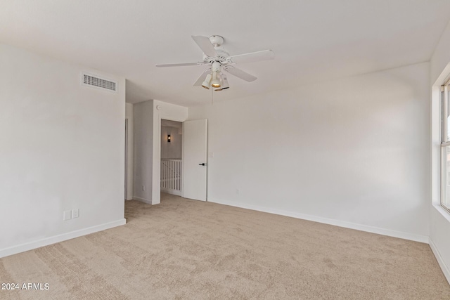 spare room with ceiling fan and light carpet