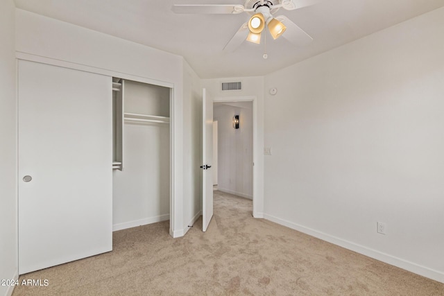 unfurnished bedroom with ceiling fan, light colored carpet, and a closet