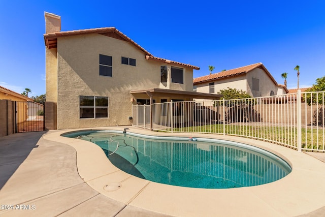 back of house featuring a fenced in pool and a patio