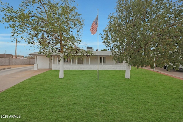 single story home with concrete driveway and a front yard