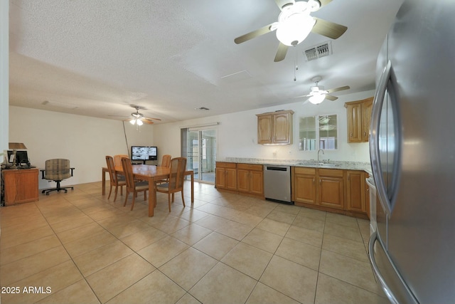 kitchen with visible vents, a sink, stainless steel appliances, light tile patterned floors, and ceiling fan