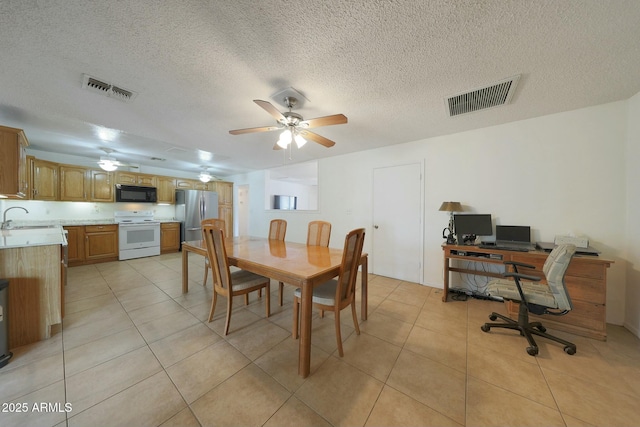 dining space featuring light tile patterned floors, visible vents, and a ceiling fan