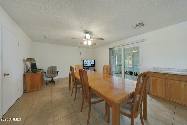 dining room with light tile patterned floors, visible vents, a textured ceiling, and a ceiling fan