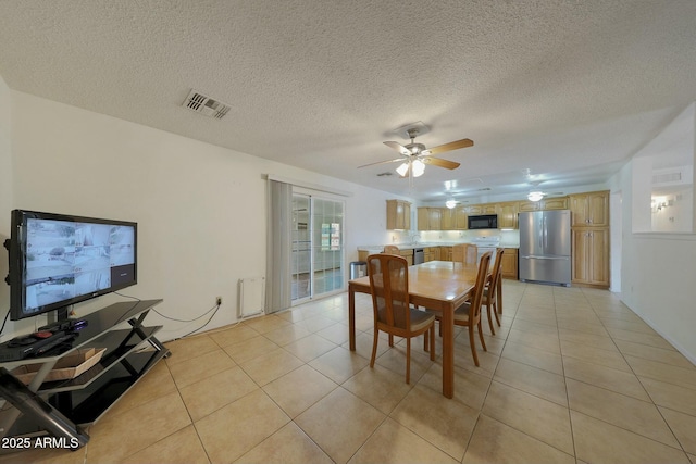 dining area featuring light tile patterned floors, visible vents, and ceiling fan