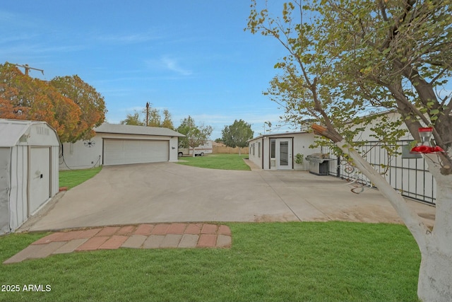 view of yard with a garage and an outbuilding