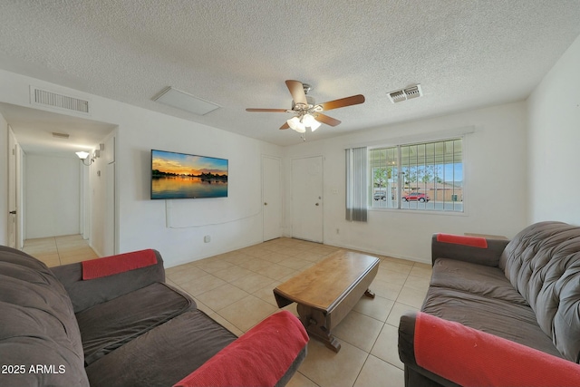 living room featuring visible vents, light tile patterned flooring, and a ceiling fan