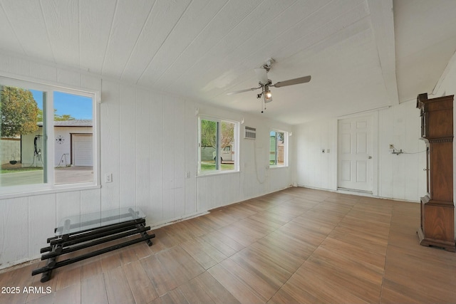 unfurnished room featuring a wall mounted air conditioner and a ceiling fan