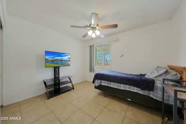 bedroom featuring light tile patterned flooring, baseboards, a textured ceiling, and ceiling fan