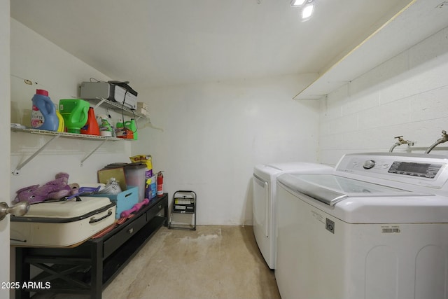 laundry area with laundry area, concrete block wall, and washer and clothes dryer