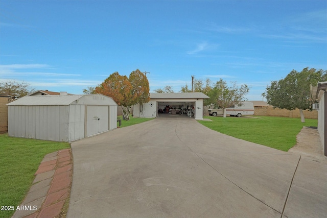 exterior space featuring a garage, driveway, a front yard, and an outdoor structure