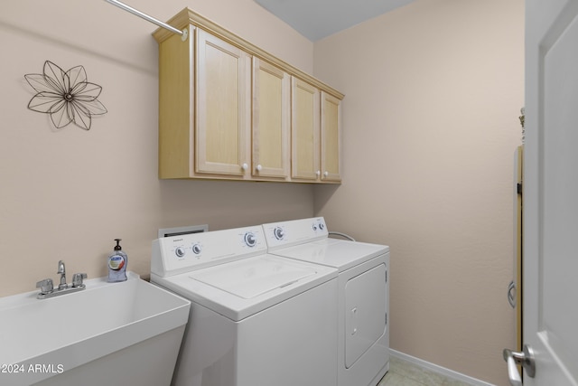 clothes washing area featuring independent washer and dryer, a sink, cabinet space, and baseboards