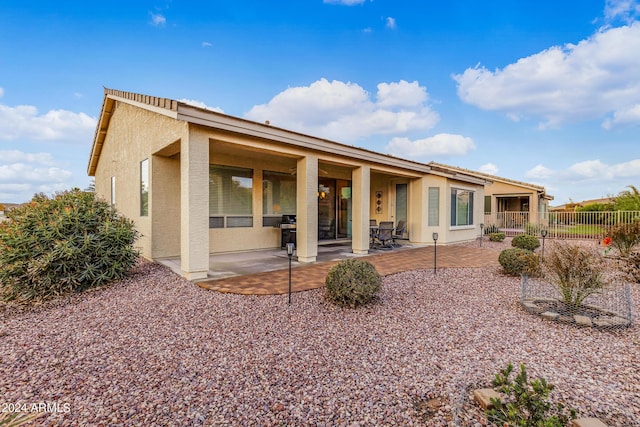 back of property featuring a patio, fence, and stucco siding