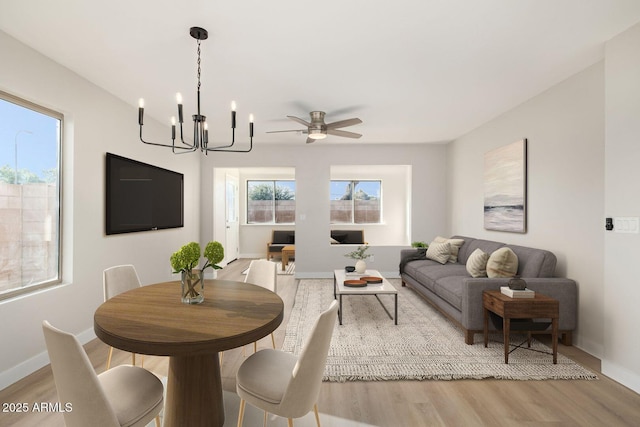 dining room featuring light hardwood / wood-style floors and ceiling fan with notable chandelier