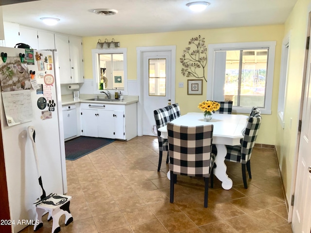 dining room featuring sink, light tile patterned floors, and plenty of natural light