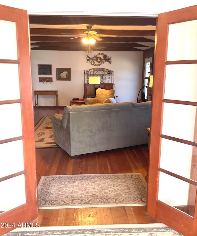 living room with beam ceiling, ceiling fan, and dark hardwood / wood-style flooring